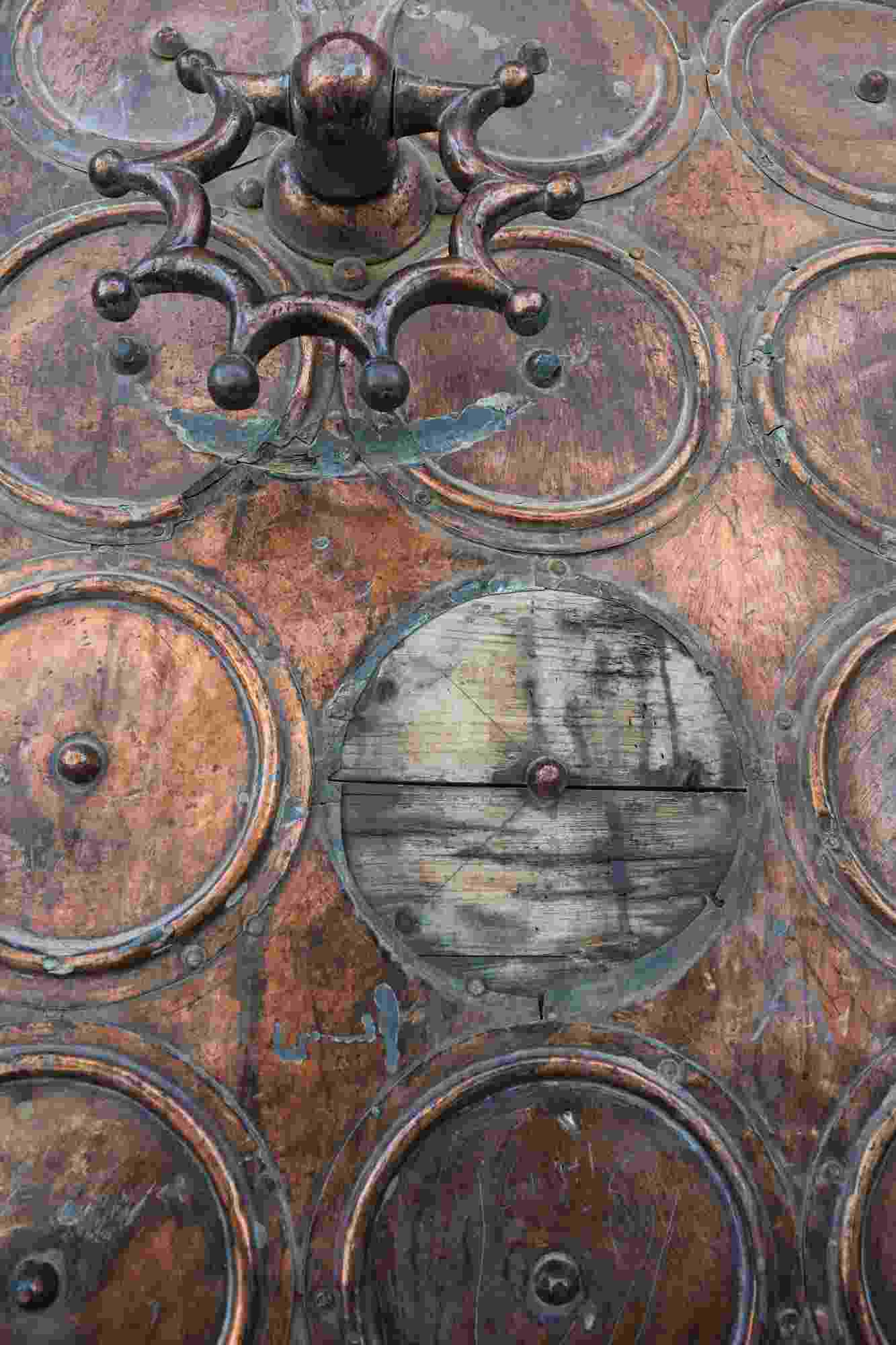 Close up view of the repeating pattern of raised circles on one of the doors of the Dome of the Rock, and an ornate spoked handle